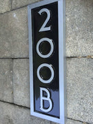 Side view of vertical custom made address number with letter rectangular sign painted black and silver