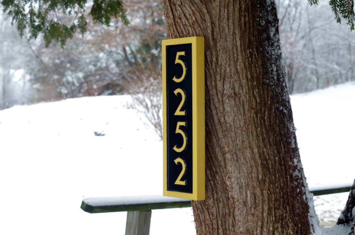 Black and gold vertical house number sign
