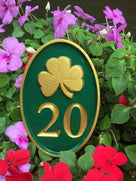 Green and gold shamrock sign with house number