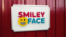 Orthodontist logo carved on rectangular sign painted in multiple colors with a white background