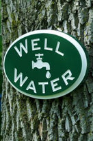 Well water sign hung on tree