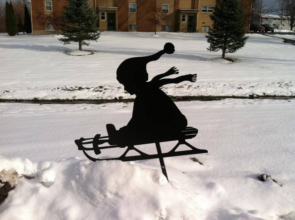 Silhouette of child going down hill in snow at a distance